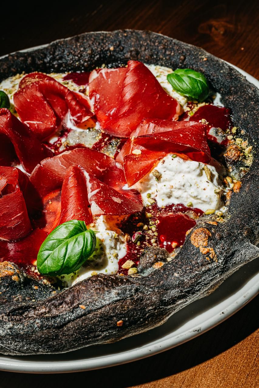 Fekete Blackery pizza bresaolával, burratával és bazsalikommal